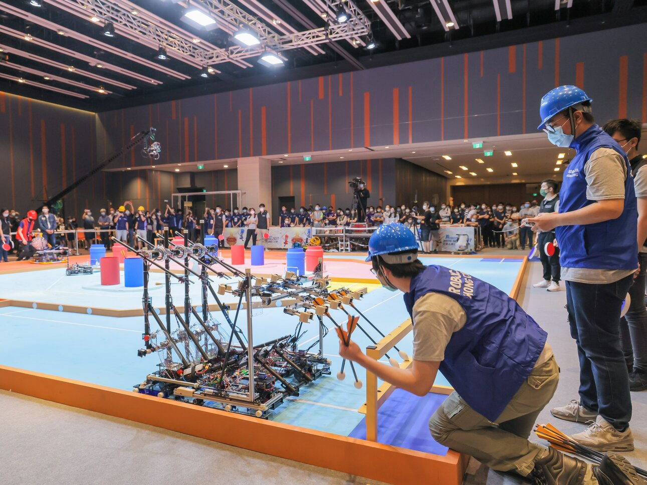 Photos 3 - 4: Each team is required to design two robots – one throwing and one defensive, to implement a series of strategic moves to shoot arrows into the pots.